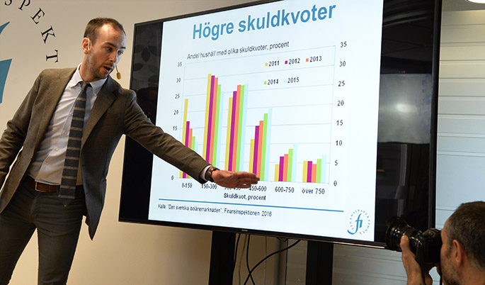 Photo: an employee at FI points at bar chart from the yearly report The Swedish Mortage Market 